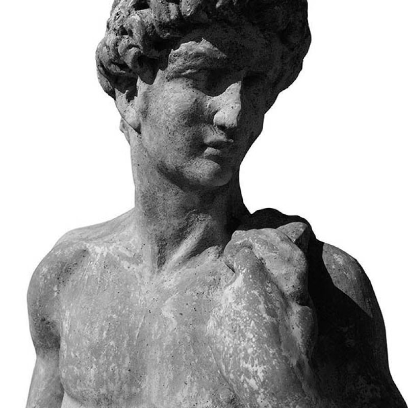 Close up of ancient stone sculpture of naked man on white backgr
